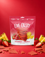 Live Crispy Strawberry + Pineapple bag with strawberry chips and fresh strawberries on red
